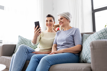 Image showing senior mother with daughter taking selfie at home