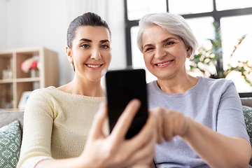 Image showing daughter and senior mother with smartphone at home