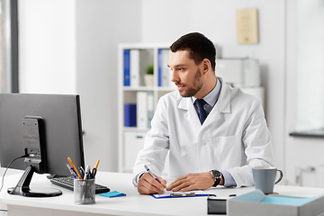 Image showing doctor with clipboard and computer at hospital