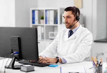 Image showing male doctor with computer and headset at hospital