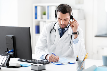 Image showing male doctor with headset and clipboard at hospital