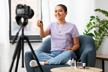 Image showing female beauty blogger with camera and lipstick