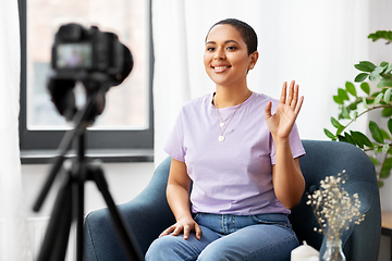 Image showing female blogger with camera video blogging at home