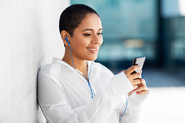 Image showing african american woman with earphones and phone