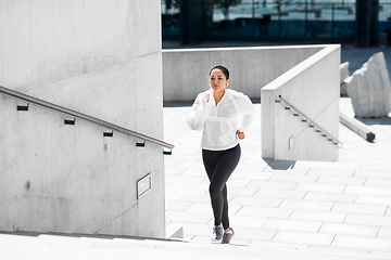 Image showing african american woman running upstairs outdoors