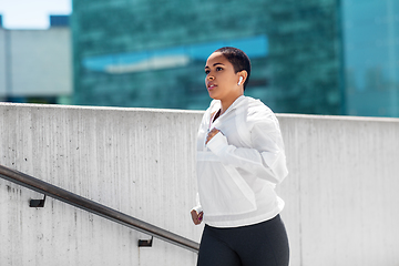 Image showing african american woman running upstairs outdoors