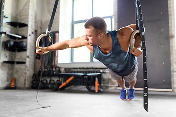 Image showing man doing exercising on gymnastic rings in gym