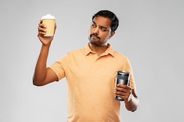 Image showing man comparing thermo cup or tumbler and coffee cup