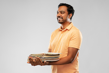 Image showing smiling young indian man sorting paper waste