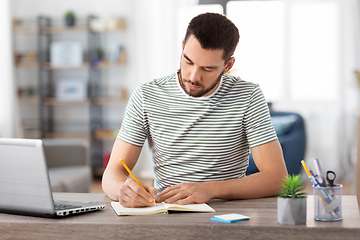 Image showing man with notebook and laptop at home office