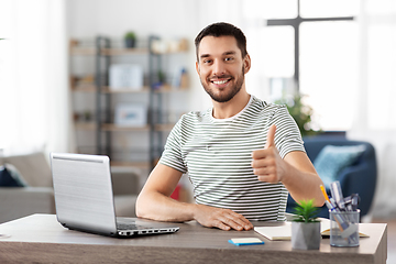 Image showing happy man with laptop working at home office