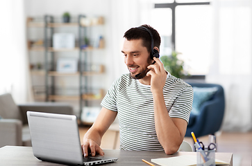 Image showing man with headset and laptop working at home