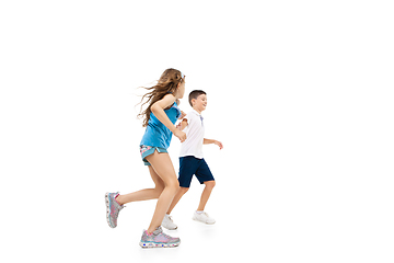 Image showing Happy little caucasian girl and boy jumping and running isolated on white background