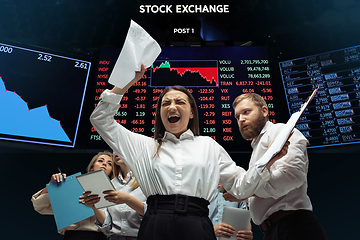 Image showing Nervous tensioned investors analyzing crisis stock market with charts on screen on background, falling stock exchange