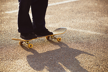 Image showing Skateboarder doing a trick at the city\'s street in summer\'s sunshine