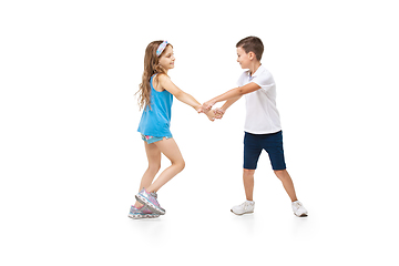 Image showing Happy little caucasian girl and boy jumping and running isolated on white background