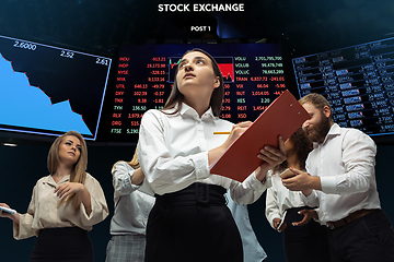 Image showing Nervous tensioned investors analyzing crisis stock market with charts on screen on background, falling stock exchange