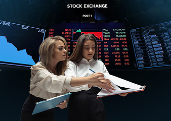 Image showing Nervous tensioned investors analyzing crisis stock market with charts on screen on background, falling stock exchange