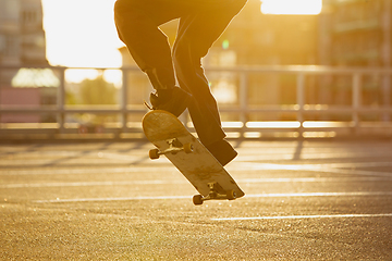 Image showing Skateboarder doing a trick at the city\'s street in summer\'s sunshine