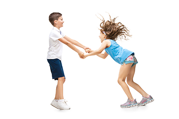 Image showing Happy little caucasian girl and boy jumping and running isolated on white background