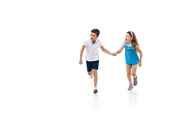 Image showing Happy little caucasian girl and boy jumping and running isolated on white background