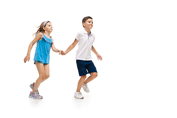 Image showing Happy little caucasian girl and boy jumping and running isolated on white background