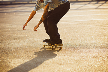 Image showing Skateboarder doing a trick at the city\'s street in summer\'s sunshine