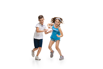 Image showing Happy little caucasian girl and boy jumping and running isolated on white background