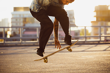 Image showing Skateboarder doing a trick at the city\'s street in summer\'s sunshine