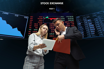 Image showing Nervous tensioned investors analyzing crisis stock market with charts on screen on background, falling stock exchange