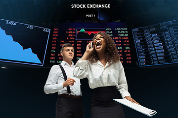 Image showing Nervous tensioned investors analyzing crisis stock market with charts on screen on background, falling stock exchange