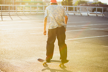 Image showing Skateboarder doing a trick at the city\'s street in summer\'s sunshine