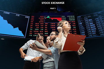 Image showing Nervous tensioned investors analyzing crisis stock market with charts on screen on background, falling stock exchange