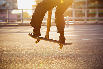 Image showing Skateboarder doing a trick at the city\'s street in summer\'s sunshine