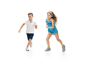 Image showing Happy little caucasian girl and boy jumping and running isolated on white background