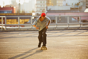 Image showing Skateboarder doing a trick at the city\'s street in summer\'s sunshine