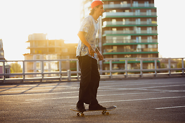 Image showing Skateboarder doing a trick at the city\'s street in summer\'s sunshine