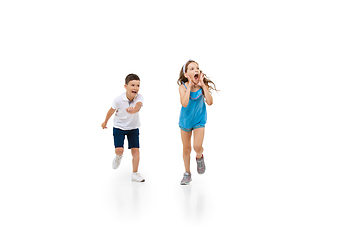 Image showing Happy little caucasian girl and boy jumping and running isolated on white background