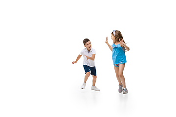 Image showing Happy little caucasian girl and boy jumping and running isolated on white background