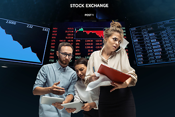 Image showing Nervous tensioned investors analyzing crisis stock market with charts on screen on background, falling stock exchange