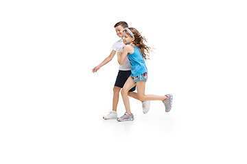 Image showing Happy little caucasian girl and boy jumping and running isolated on white background