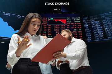 Image showing Nervous tensioned investors analyzing crisis stock market with charts on screen on background, falling stock exchange