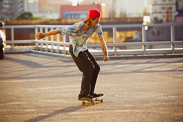 Image showing Skateboarder doing a trick at the city\'s street in summer\'s sunshine