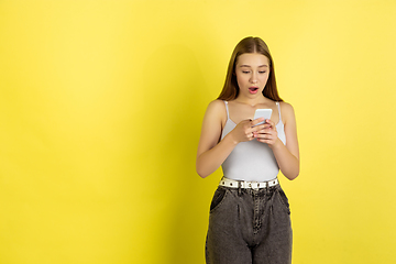 Image showing Caucasian young girl\'s portrait isolated on yellow studio background. Beautiful female model. Concept of human emotions, facial expression, sales, ad, youth culture.