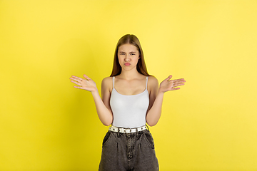 Image showing Caucasian young girl\'s portrait isolated on yellow studio background. Beautiful female model. Concept of human emotions, facial expression, sales, ad, youth culture.