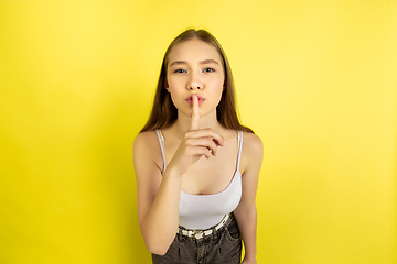 Image showing Caucasian young girl\'s portrait isolated on yellow studio background. Beautiful female model. Concept of human emotions, facial expression, sales, ad, youth culture.