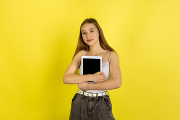 Image showing Caucasian young girl\'s portrait isolated on yellow studio background. Beautiful female model. Concept of human emotions, facial expression, sales, ad, youth culture.