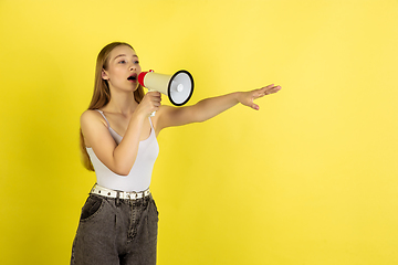 Image showing Caucasian young girl\'s portrait isolated on yellow studio background. Beautiful female model. Concept of human emotions, facial expression, sales, ad, youth culture.