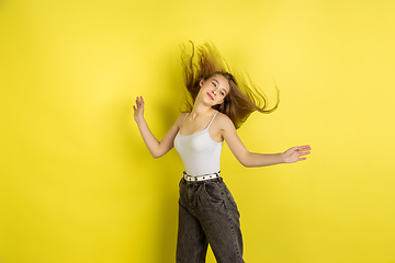 Image showing Caucasian young girl\'s portrait isolated on yellow studio background. Beautiful female model. Concept of human emotions, facial expression, sales, ad, youth culture.