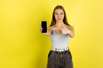 Image showing Caucasian young girl\'s portrait isolated on yellow studio background. Beautiful female model. Concept of human emotions, facial expression, sales, ad, youth culture.